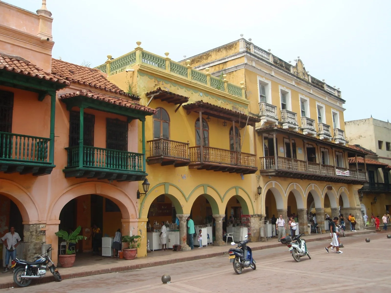 Casas de dos pisos con balcones sobre los arcos del portal