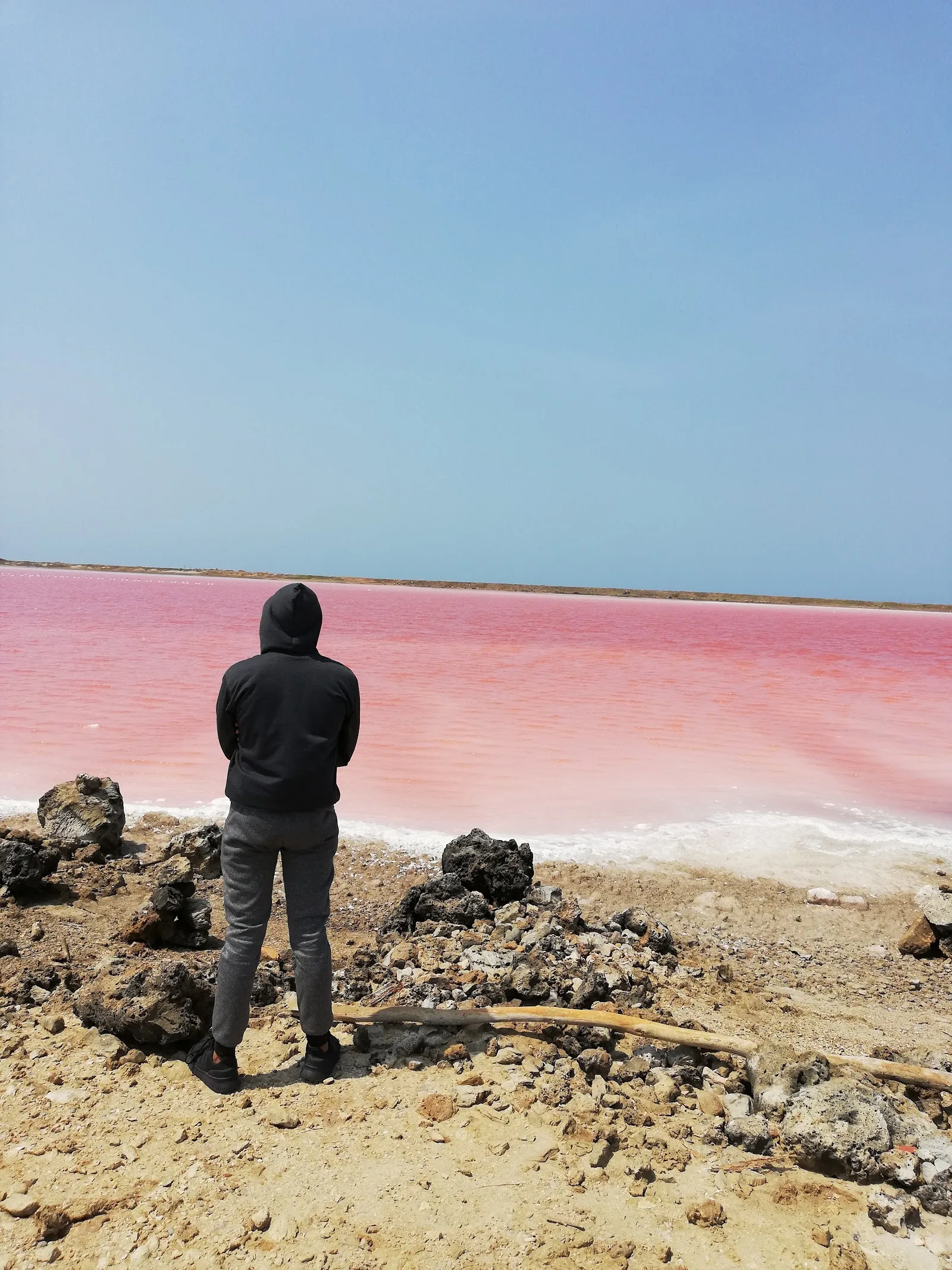 Visitante frente al agua rosada de las salinas de Galerazamba