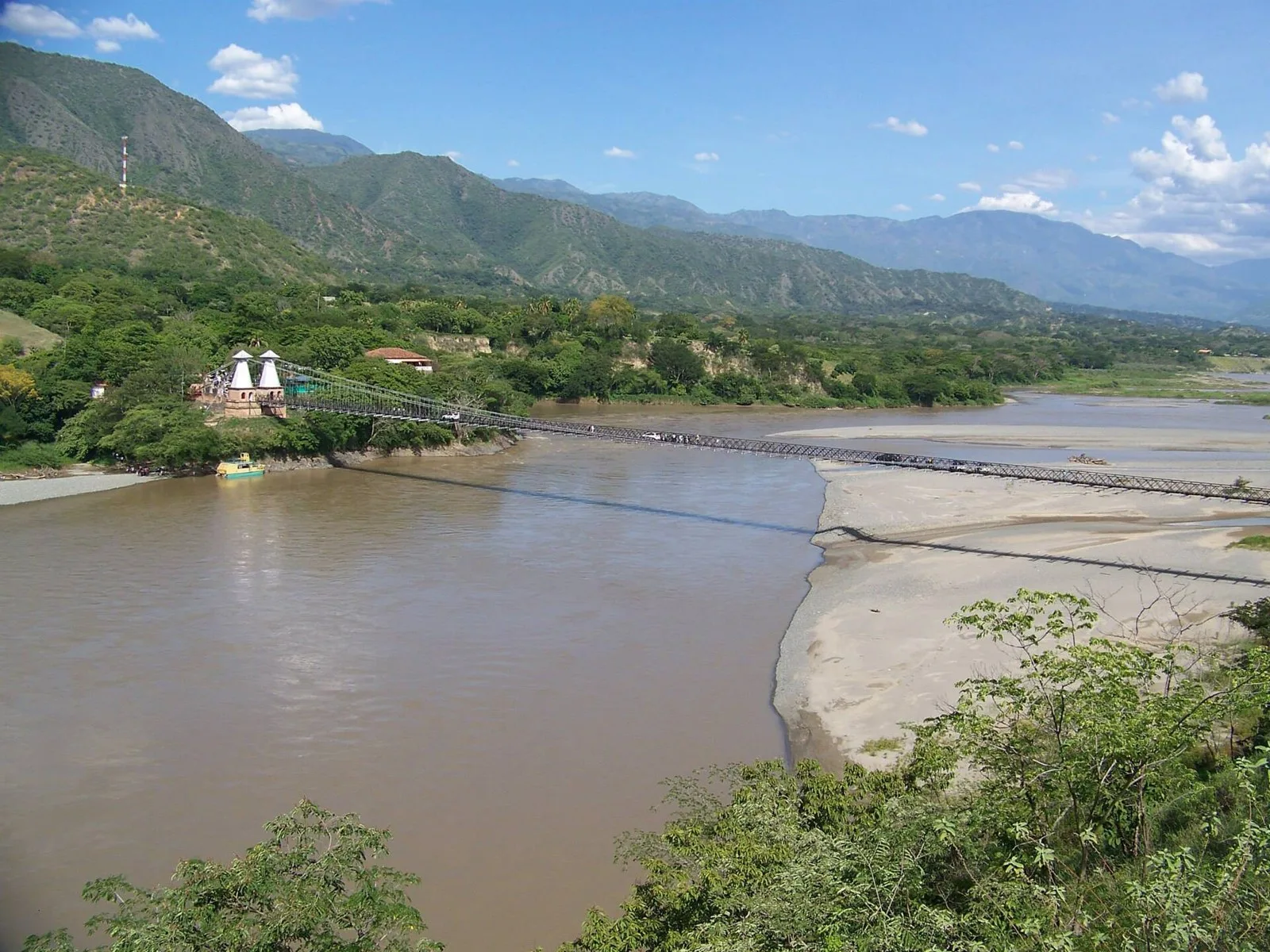 El Puente de Occidente cruzando el río Cauca, con las montañas del cañón al fondo