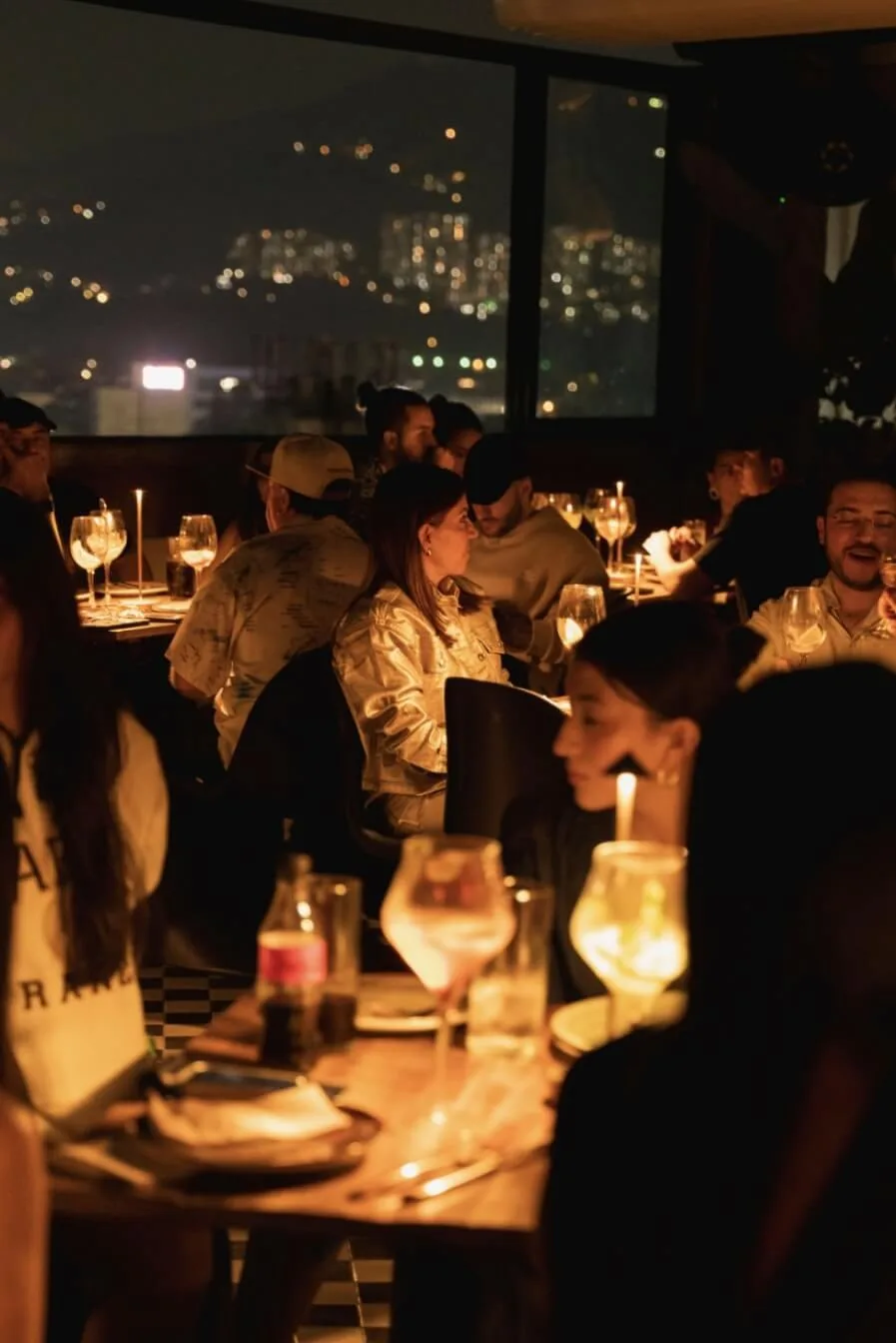 The Terrace de noche, con mesas iluminadas y la ciudad al fondo