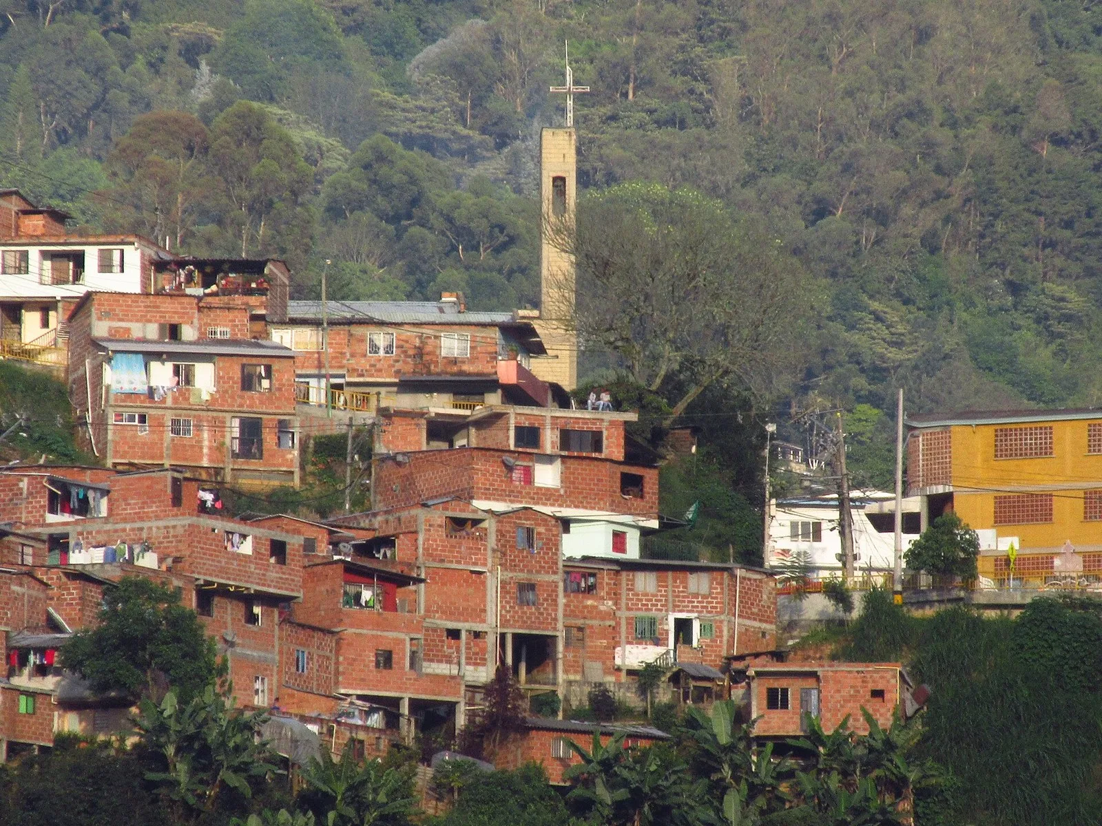 Casas de la Comuna 8 con la torre de la iglesia Santa María de La Sierra al fondo