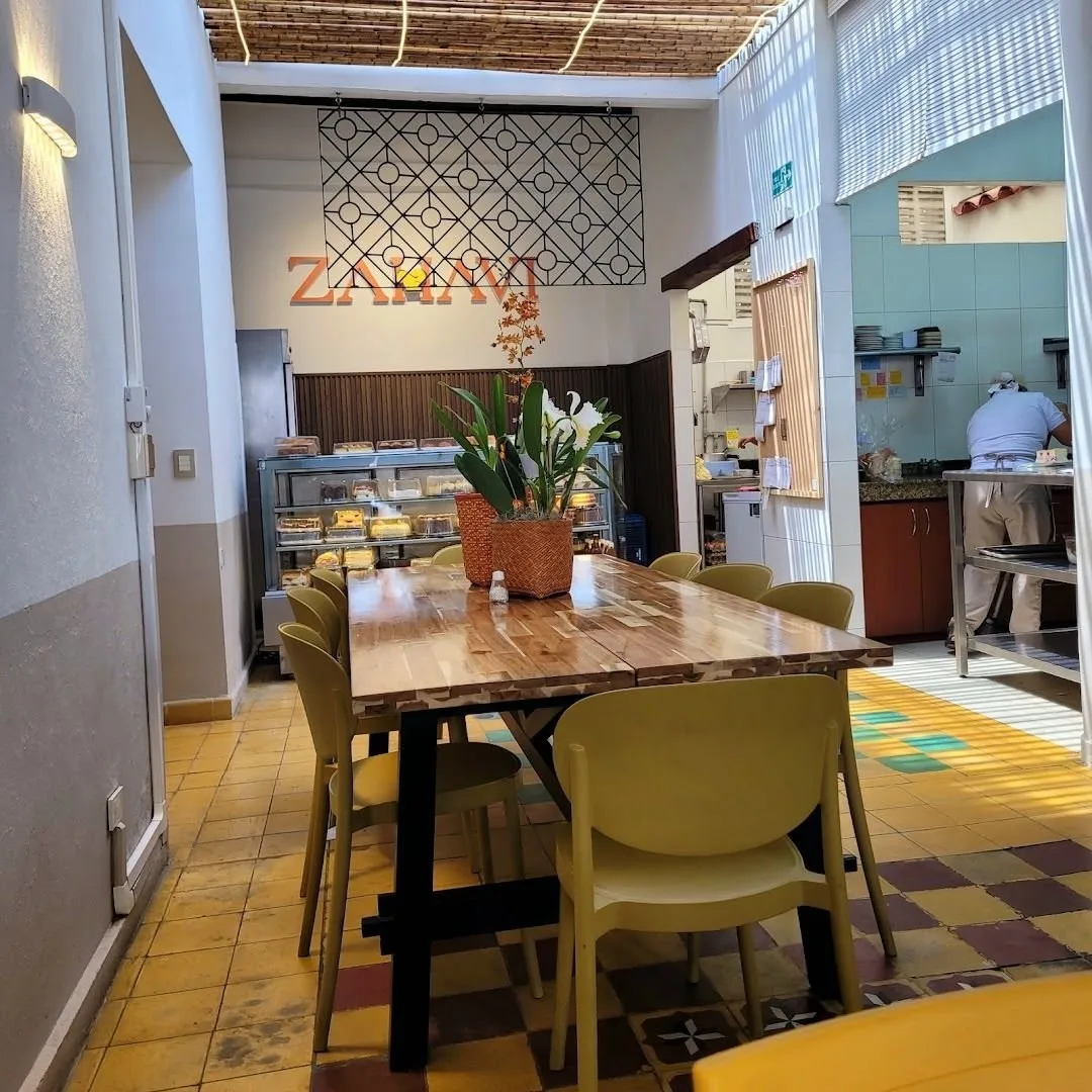 Salón de Zahavi en San Antonio, con su mesa larga y la vitrina de tortas al fondo