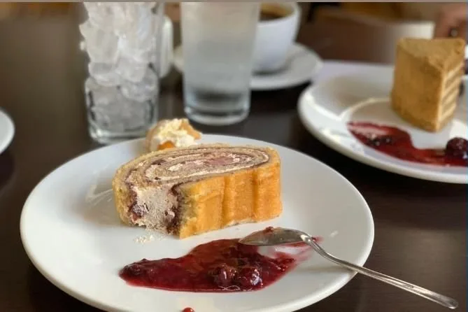 Rollo de torta con salsa de frutos rojos servido en Zahavi