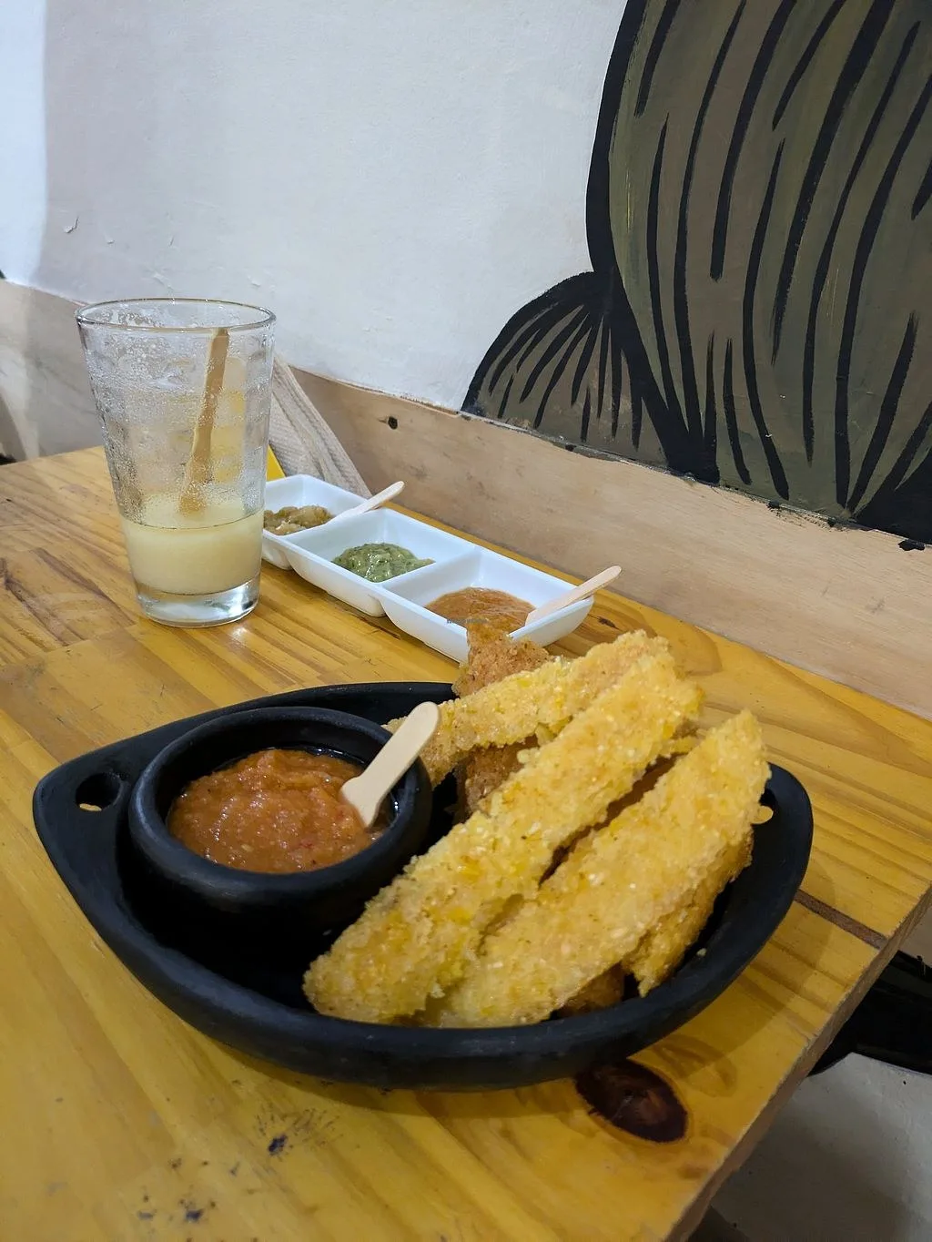 Arepa en tiras con hogao y jugo en una mesa de Zea Maíz